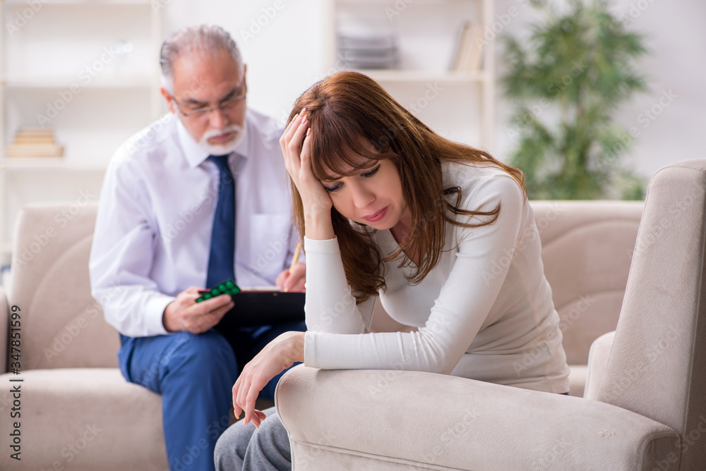 Young woman visiting old male doctor psychologist Young woman visiting old male doctor psychologist