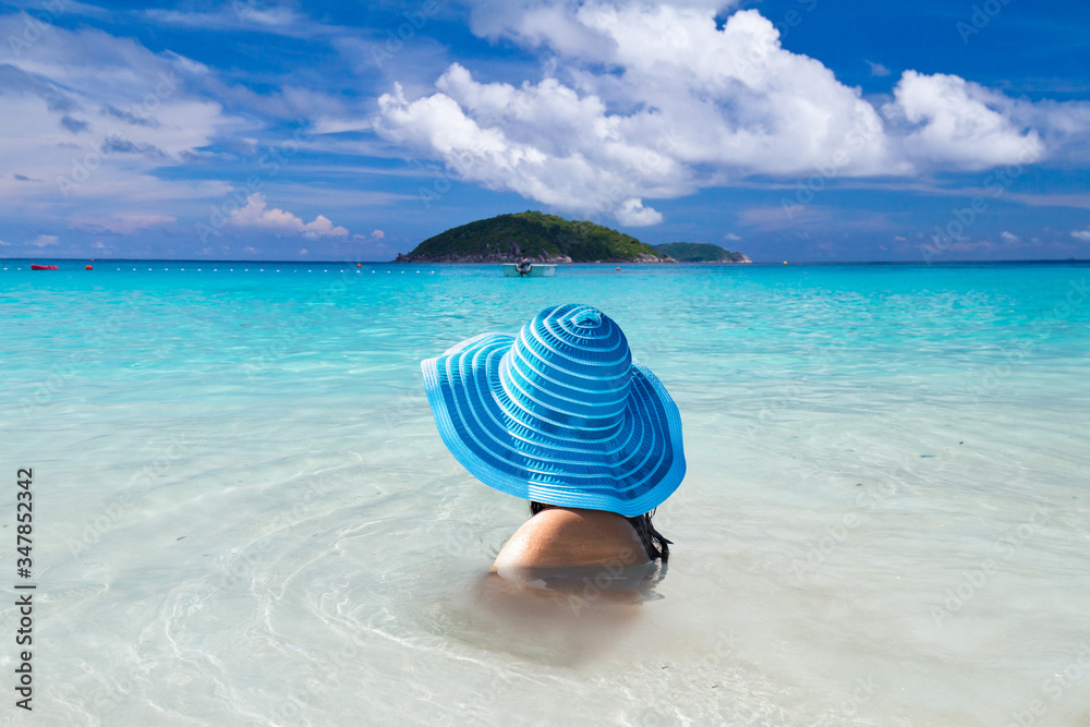 Woman in hat in the water of tropical beach, Thailand Woman in hat in the water of tropical beach, Thailand