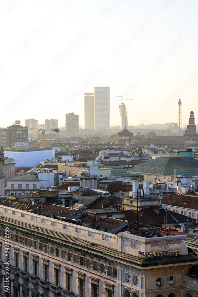 Milano, Italy, march 22, 2019: from the roof top of the Duomo church the view of the city at sunset time, in the back ground the three new towers (one still in construction) of the Citylife district
