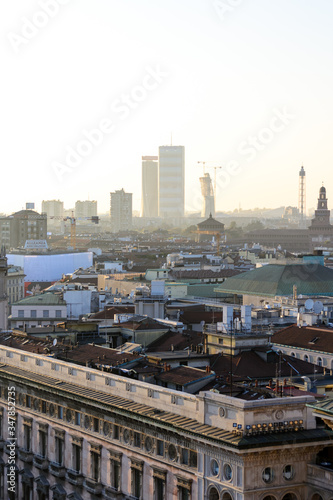 Milano, Italy, march 22, 2019: from the roof top of the Duomo church the view of the city at sunset time, in the back ground the three new towers (one still in construction) of the Citylife district