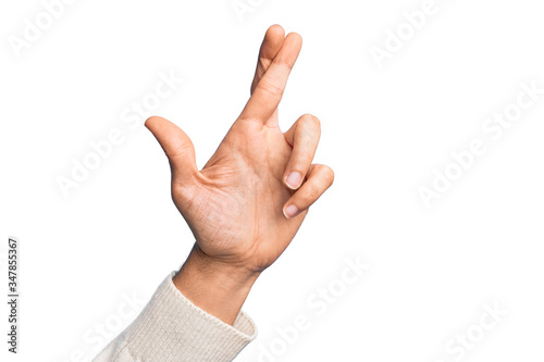 Hand of caucasian young man showing fingers over isolated white background gesturing fingers crossed, superstition and lucky gesture, lucky and hope expression photo