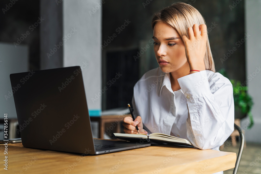 Young business woman working home, sitting front laptop, looking screen and thinking. Isolated woman distance learning Young business woman working home, sitting front laptop, looking screen and thinking. Isolated woman distance learning
