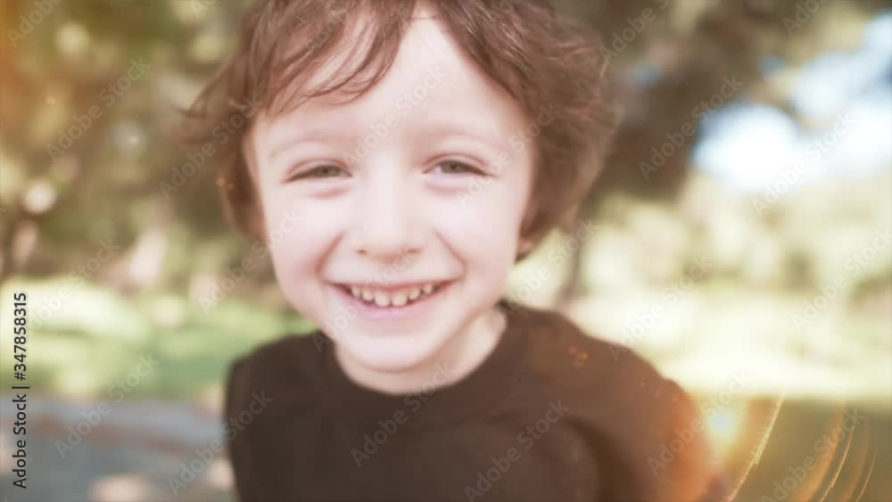 Portrait of preschool cute kid in nature. Happy young funny baby boy face is smiling to camera.