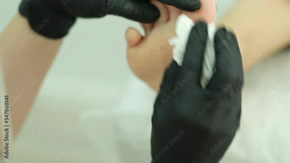Podolog. Cleaning the feet with a napkin. Podolog. Cleaning the feet with a napkin.