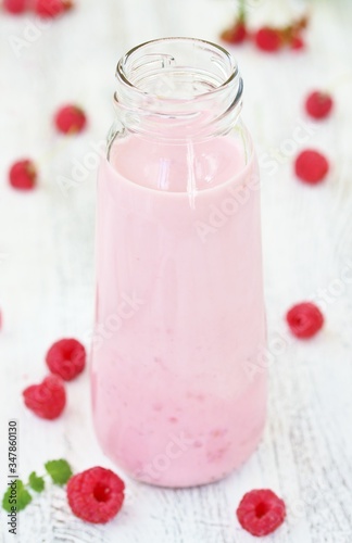 Raspberry milk shake. Milkshake with raspberries in a bottle with a tube. A milky raspberry cocktail. Milk and raspberries are blended with a blender.