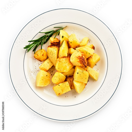 Fried baked potatoes with rosemary on a white plate