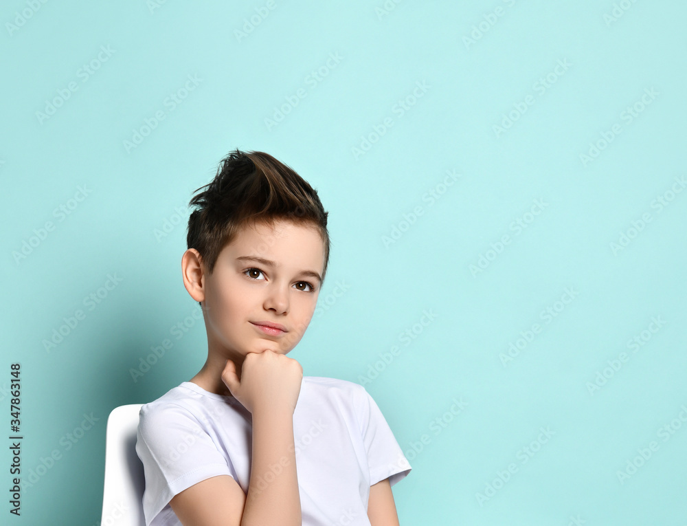 Smiling happy little boy pondered, propping his head on his fist. Facial expression, emotions, childhood, style and fashion. Smiling happy little boy pondered, propping his head on his fist. Facial expression, emotions, childhood, style and fashion.