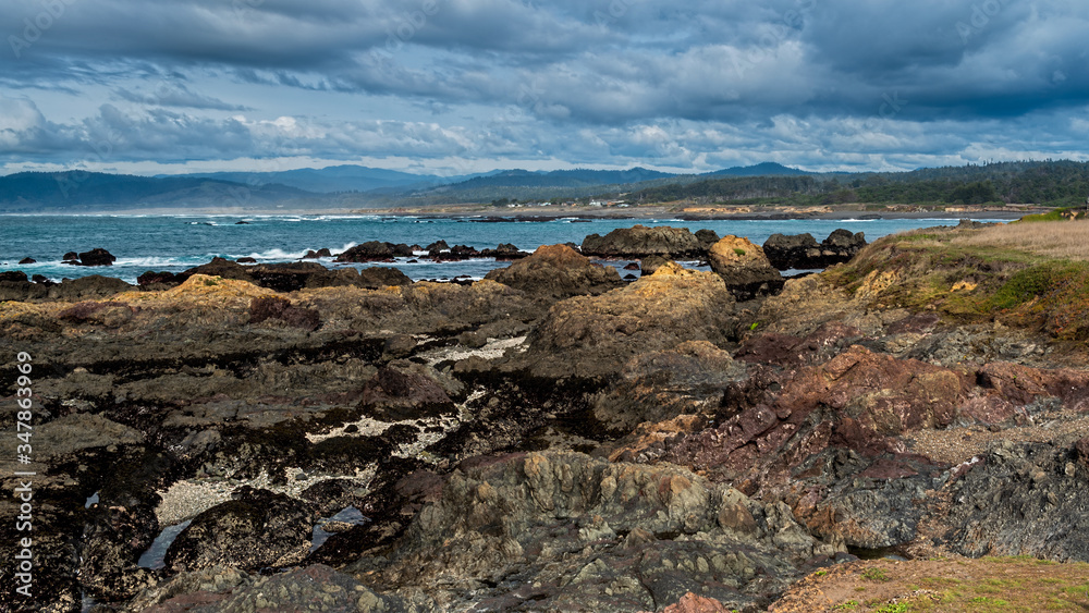 Rocky shore in Mendocino County against partly cloudy skies, Laguna Point State park, a tourist attraction in Northern California 