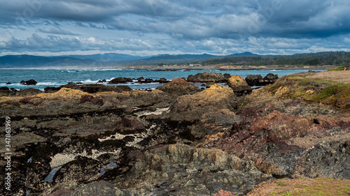 Rocky shore in Mendocino County against partly cloudy skies, Laguna Point State park, a tourist attraction in Northern California 
