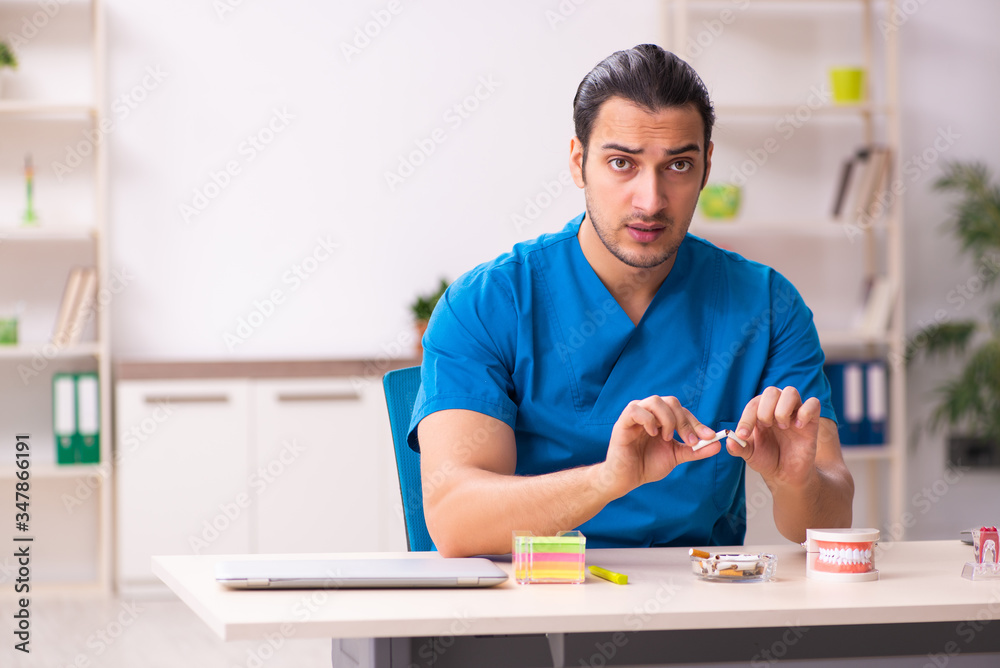 Young male dentist working in the clinic Young male dentist working in the clinic