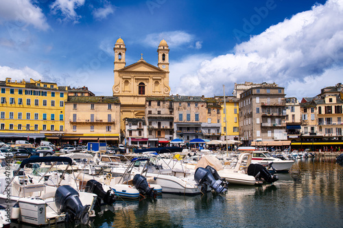 vieuw on église Saint Jean-Baptiste in Bastia from the vieux port with some boats resting in the habour during summertime photo