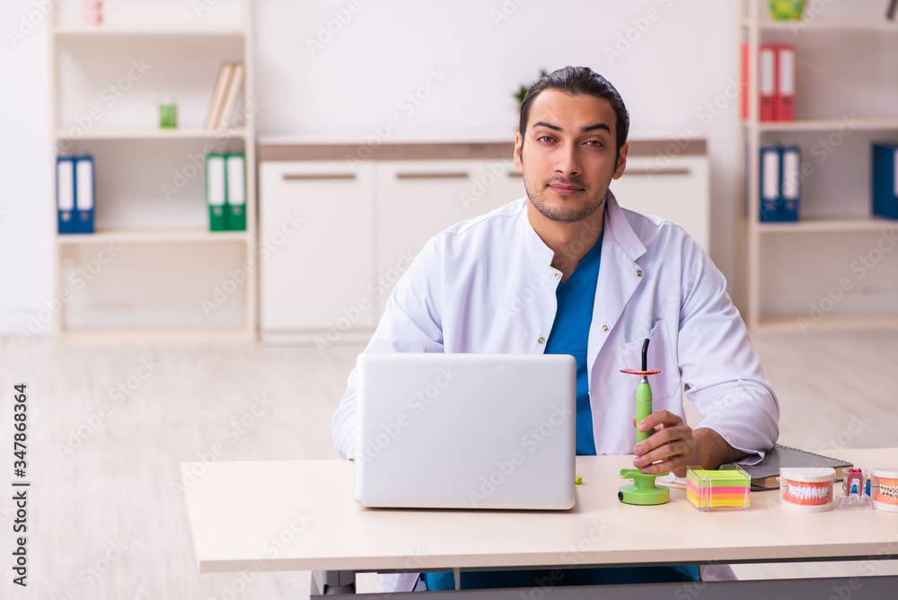 Young male dentist working in the clinic Young male dentist working in the clinic