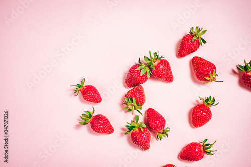 Fresh strawberry on the light pink background. View from above. Place for text.