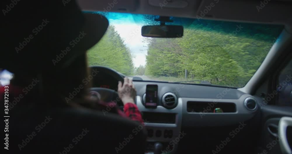 Beautiful happy woman in red driving her car. Female tourist wearing straw hat Beautiful happy woman in red driving her car. Female tourist wearing straw hat