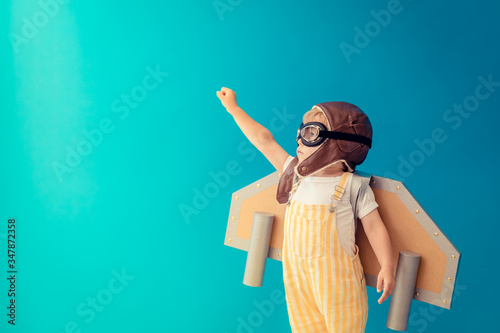 Happy child playing with toy paper wings photo