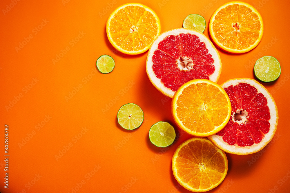 Fresh slices of citrus on the orange background. View from above. Place for text. Fresh slices of citrus on the orange background. View from above. Place for text.