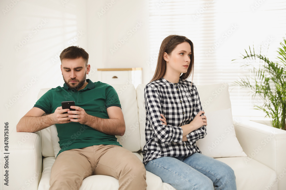 Young man preferring smartphone over his girlfriend at home. Relationship problems Young man preferring smartphone over his girlfriend at home. Relationship problems