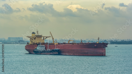 Photography Loading anchored oil supertanker via a ship-to-ship oil transfer (STS) from raid