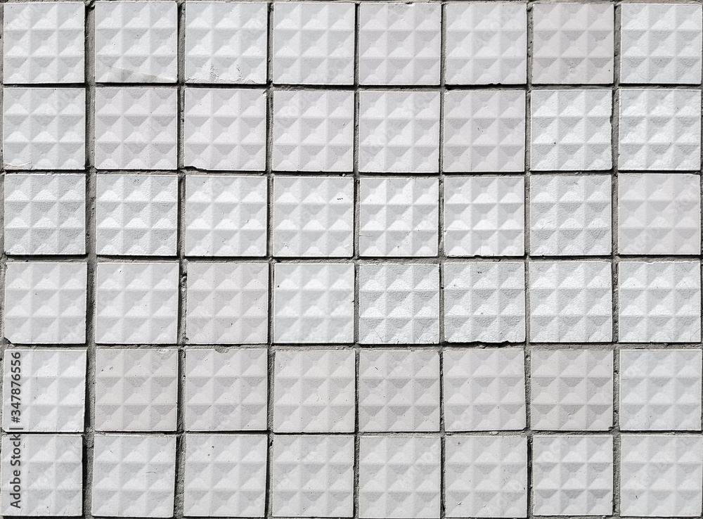 Fototapeta premium Old textured square white ceramic tiles.