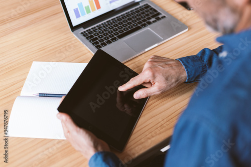 Male hand pointing at tablet screen. Businessman working remotely from home or coworking place.