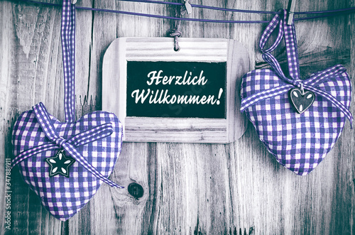 Herzlich Willkommen zwei Herzen blau weiß kariert und Tafel mit Text photo