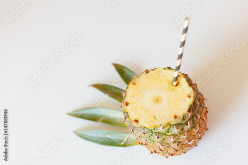 ripe pineapple fruit with a sliced top, cocktail roll, stylized green leaves, tropical bar concept