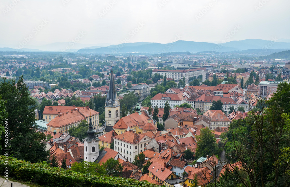 Aerial view of the old city Ljubljana, the capital of Slovenia. Buildings with red tile roofs, mountain range in the background, seen from city castle hill