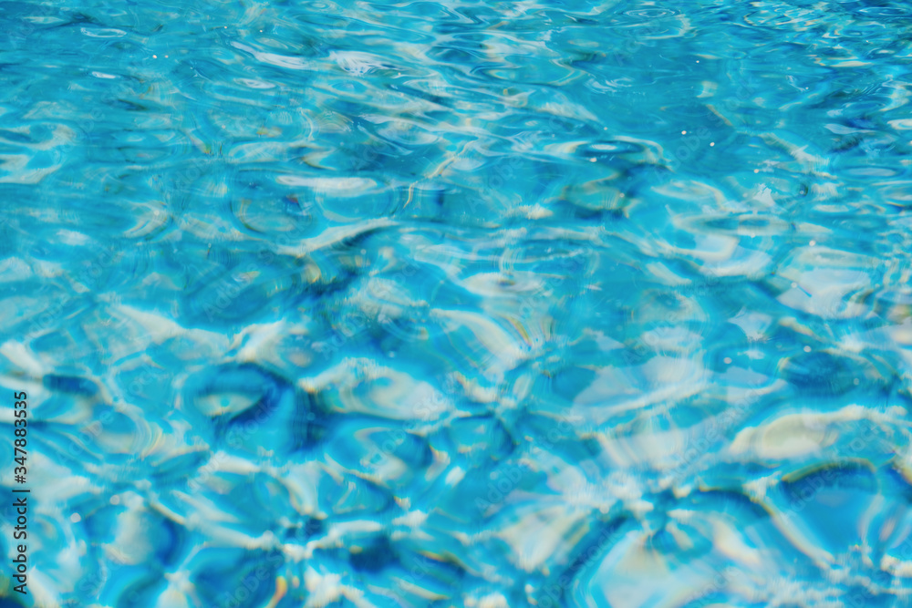 Swimming pool water texture, bright aqua blue color abstract summer blurred background with copy space 