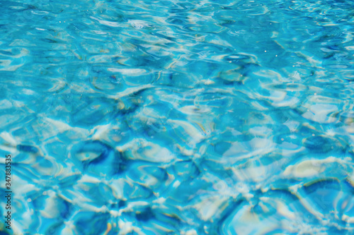 Swimming pool water texture, bright aqua blue color abstract summer blurred background with copy space 
