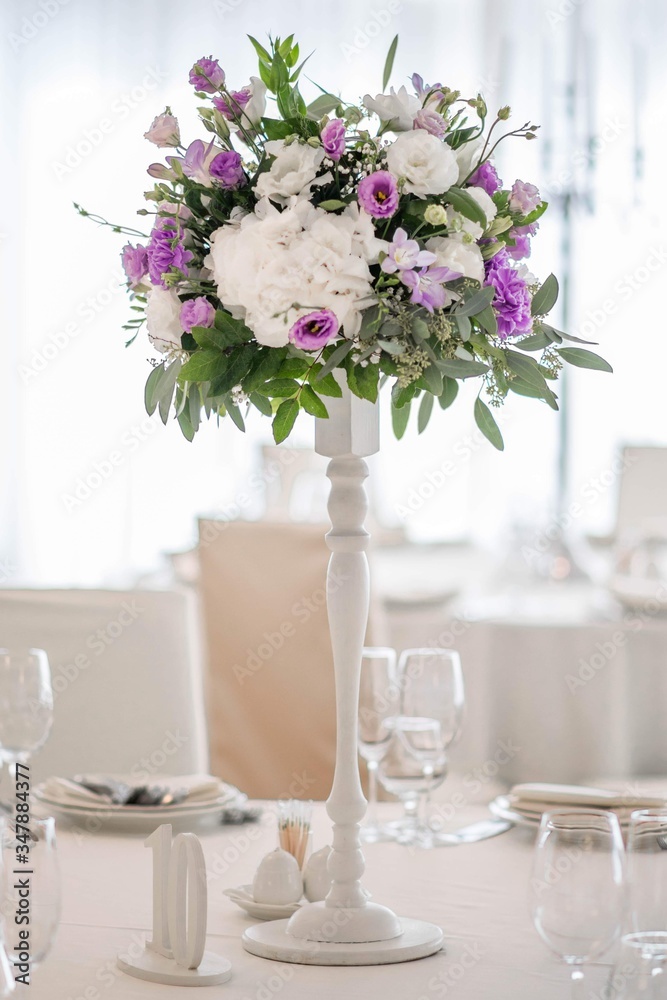 Wedding table decorated on mauve color. Centerpiece full of violet flowers in the middle