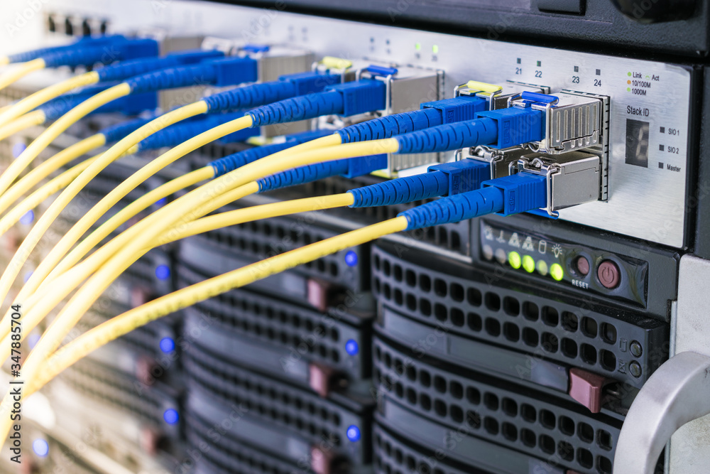 Concept of fast broadband access to the network. A bunch of fiber-optic Internet wires are connected to the router modules. Yellow telecommunications cable in the server room of the data center. Concept of fast broadband access to the network. A bunch of fiber-optic Internet wires are connected to the router modules. Yellow telecommunications cable in the server room of the data center.