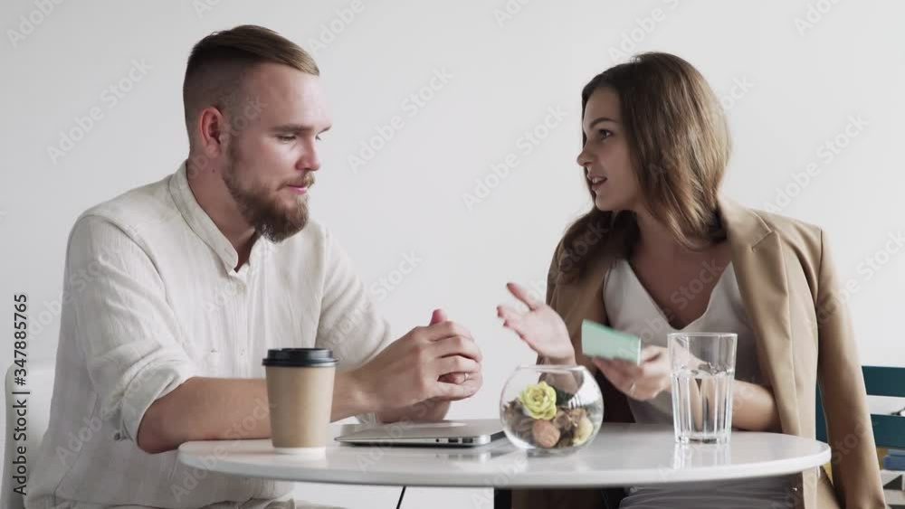 Two young people work together. They are discussing and preparing the contract. It is a business meeting. Two young people work together. They are discussing and preparing the contract. It is a business meeting.
