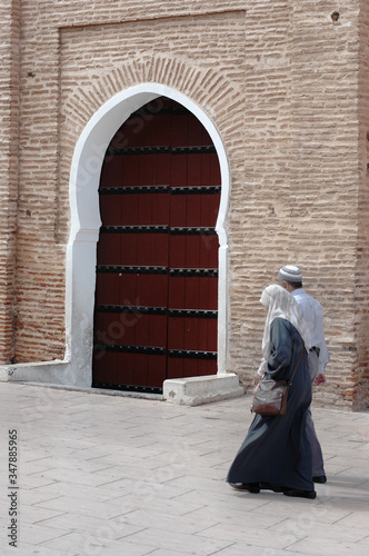 Couple walking in front of Marrakech Koutoubia Mosque photo