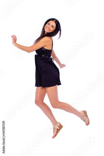 Young beautiful brunette in a black dress on a white background