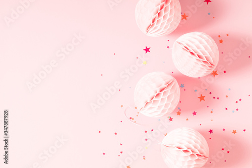 Festive pink background with confetti, paper decoration. Holiday concept on pastel pink background. Birthday, wedding, party. Flat lay, top view, copy space