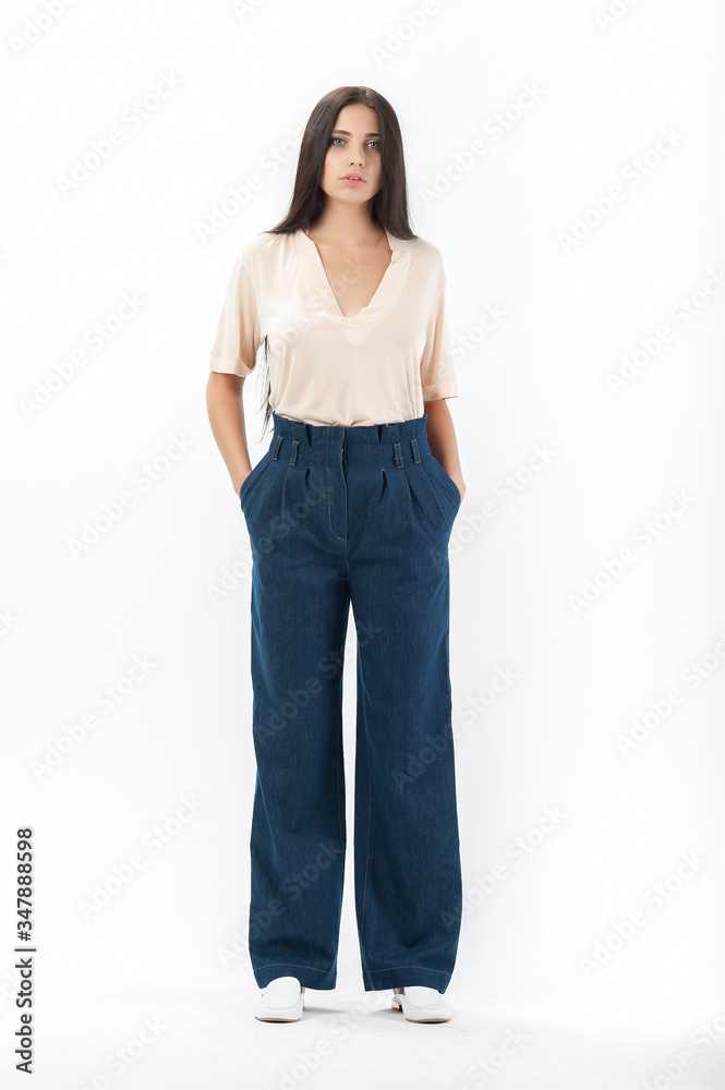 brunette posing in clothes for a catalog on a white background brunette posing in clothes for a catalog on a white background