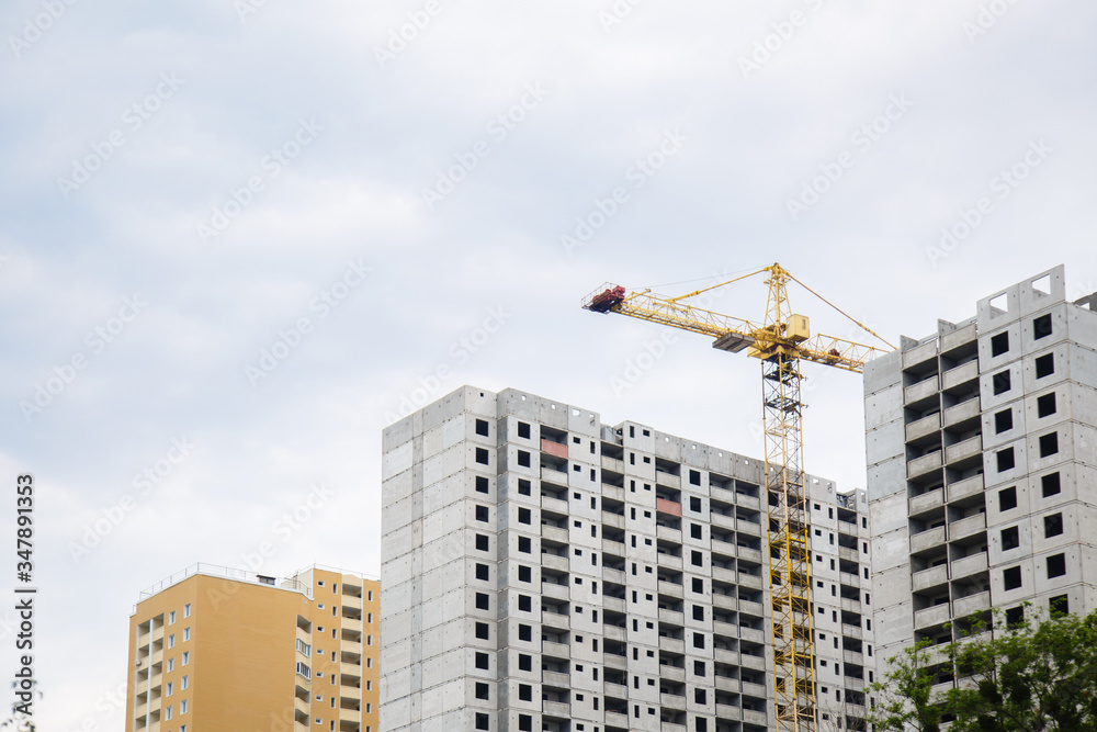 construction of iron-concrete high-rise building. Construction workplace in the summer. Details of unfinished building on the construction site. The erection of a new residential multi-storey house construction of iron-concrete high-rise building. Construction workplace in the summer. Details of unfinished building on the construction site. The erection of a new residential multi-storey house