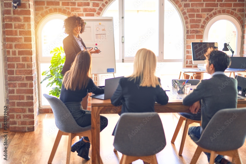 Obraz premium Group of business workers working together in a meeting. One of them making presentation to colleagues at the office