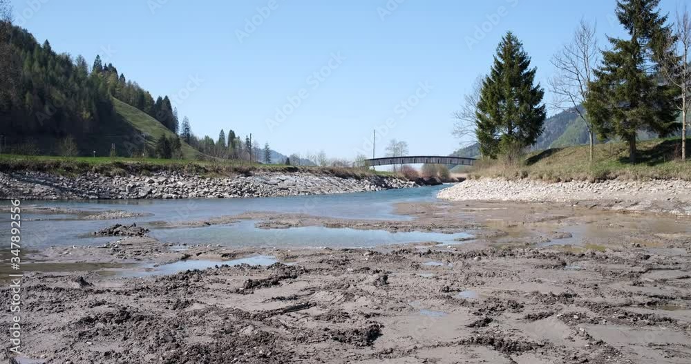 OBERIBERG, SWITZERLAND - APRIL 22, 2020: The level of the Minster River at Oberiberg has fallen during the dry season and mud is showing OBERIBERG, SWITZERLAND - APRIL 22, 2020: The level of the Minster River at Oberiberg has fallen during the dry season and mud is showing