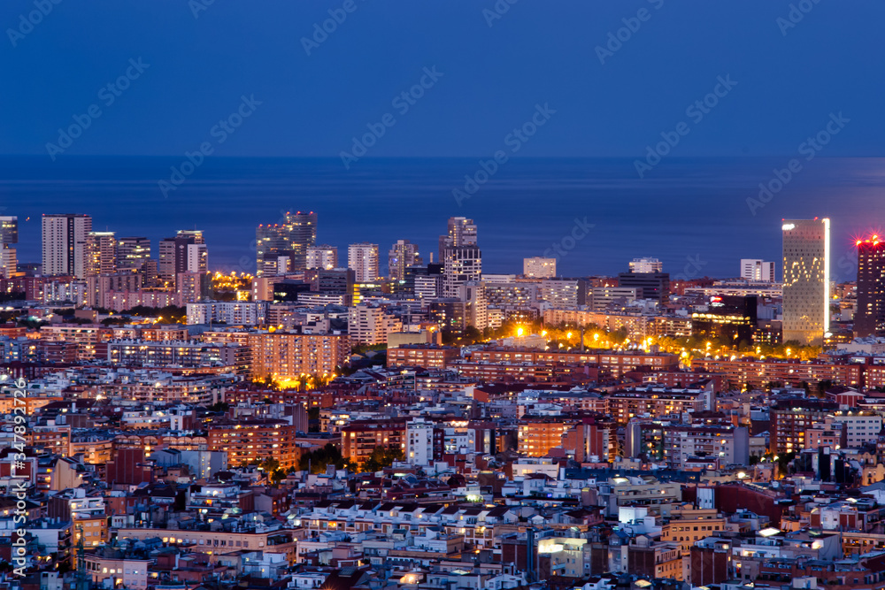 Barcelona iluminada una noche de Primavera, con luna llena, la tranquilidad de la ciudad y la vista de los edificios de diagonal Mar