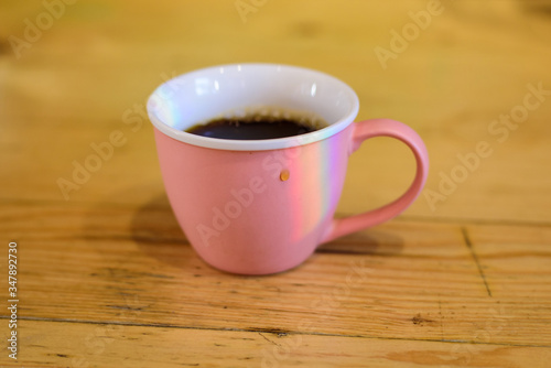 Pink cup with hot coffee with drop and rainbow