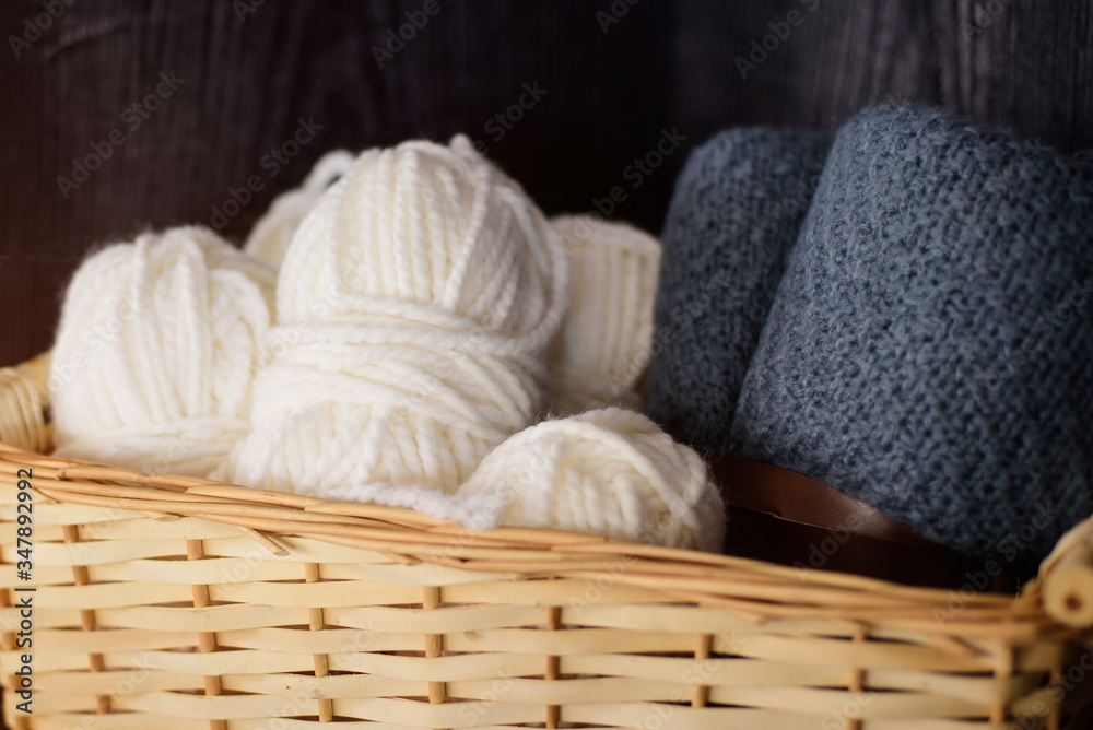 Woolen threads and plaid in wicker basket indoors