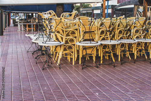 Chairs y tables collected chained together on a bar terrace waiting to use without clients