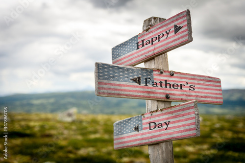 Happy fathers day text on wooden american flag signpost outdoors in nature.