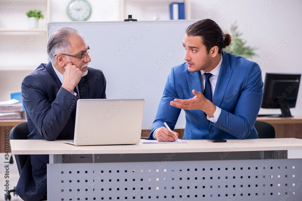 Yound and old employees in business presentation concept