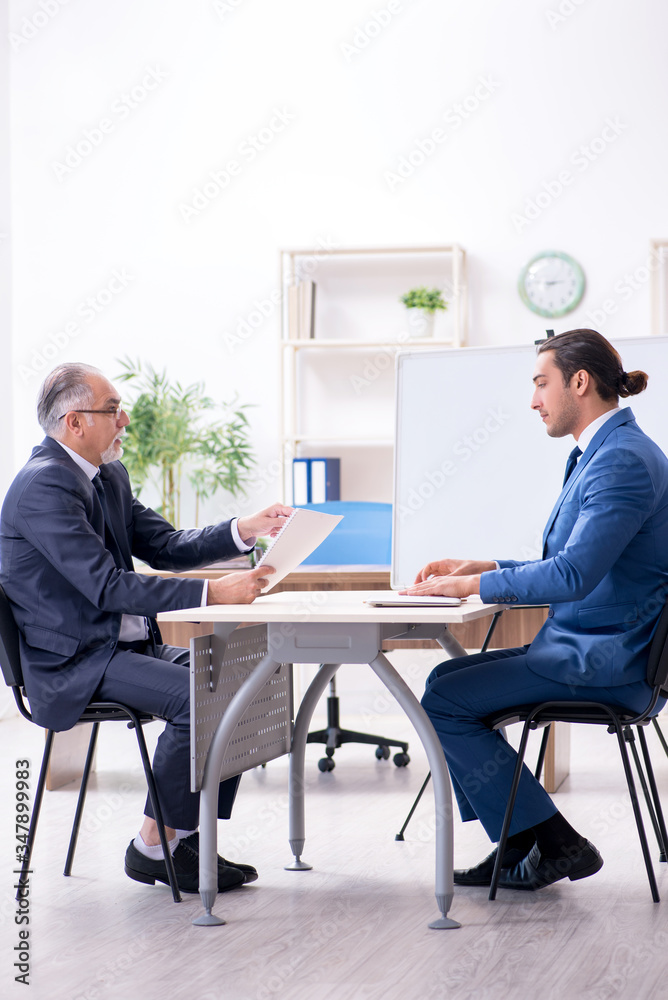 Yound and old employees in business presentation concept Yound and old employees in business presentation concept