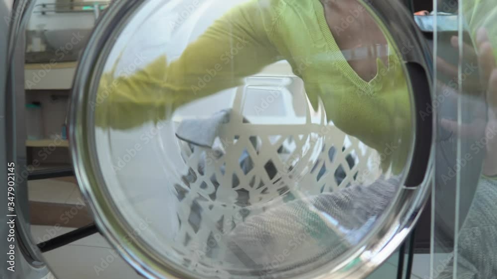 Thin woman bringing clothes to washing machine at living room. Domestic shore, cleaning laundry day concept.
Thin woman bringing clothes to washing machine at living room. Domestic shore, cleaning laundry day concept.
