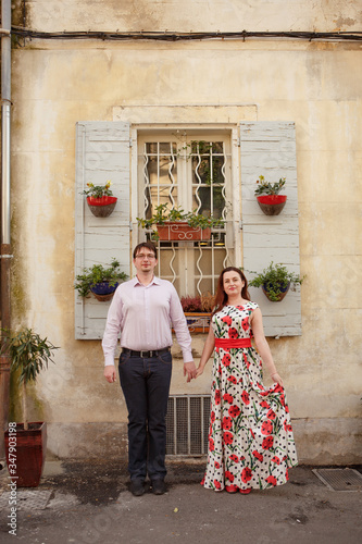 Couple stand in background of window in Provence