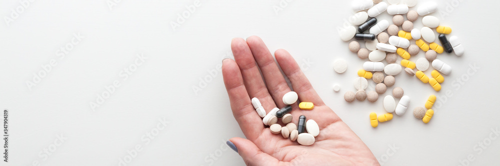 Hand with pills on a white background. Copy space. Panorama Hand with pills on a white background. Copy space. Panorama