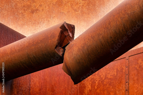 Broken off rust-coloured concrete column on a facade